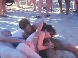 Trio sex op het naakt strand terwijl mensen toe kijken